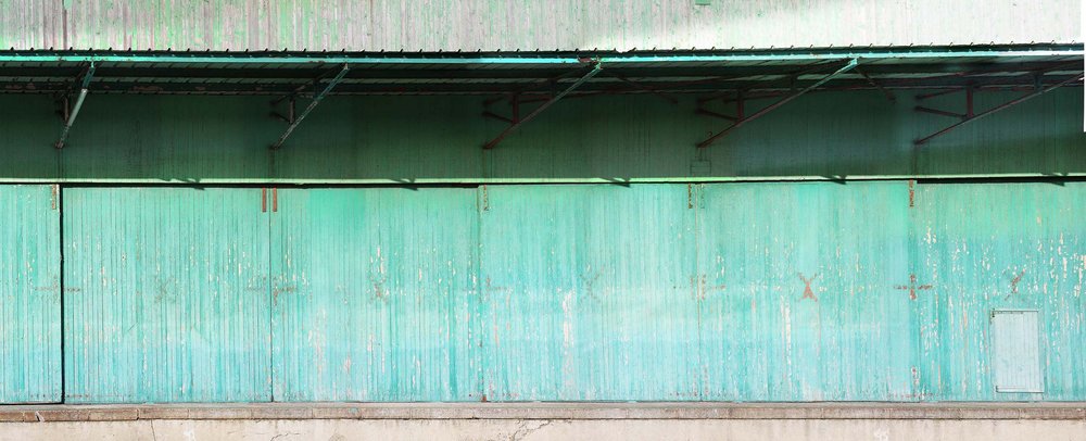 papier peint panoramique matière brute présentant une porte bleue en bois