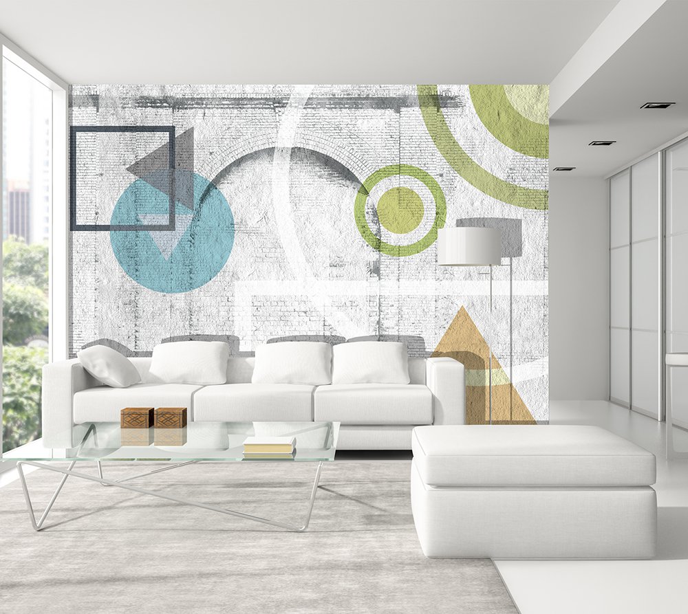 papier peint panoramique dans un salon composé de motifs géométriques en couleur peints sur un mur de briques blanches